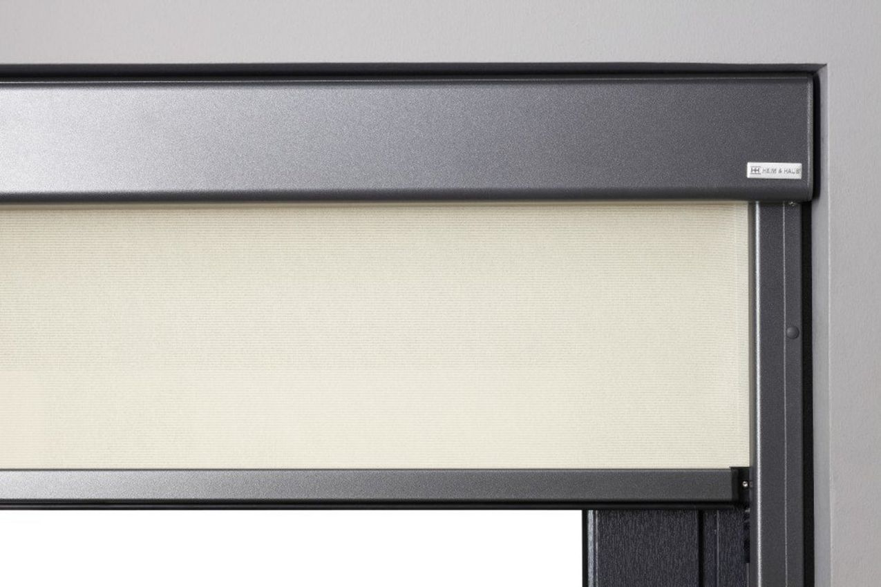 Nahaufnahme eines schwarzen Fensterrahmens mit einem hellen, heruntergelassenen Rollladen