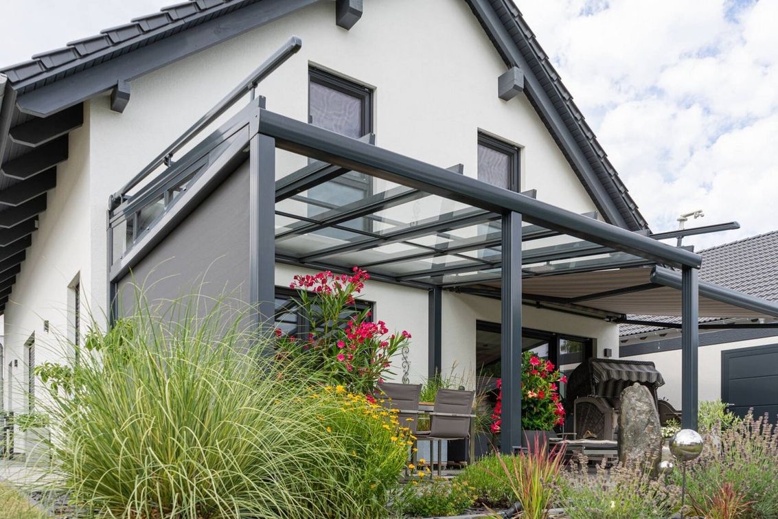 Einfamilienhaus mit moderner Glasüberdachung und bepflanzter Terrasse